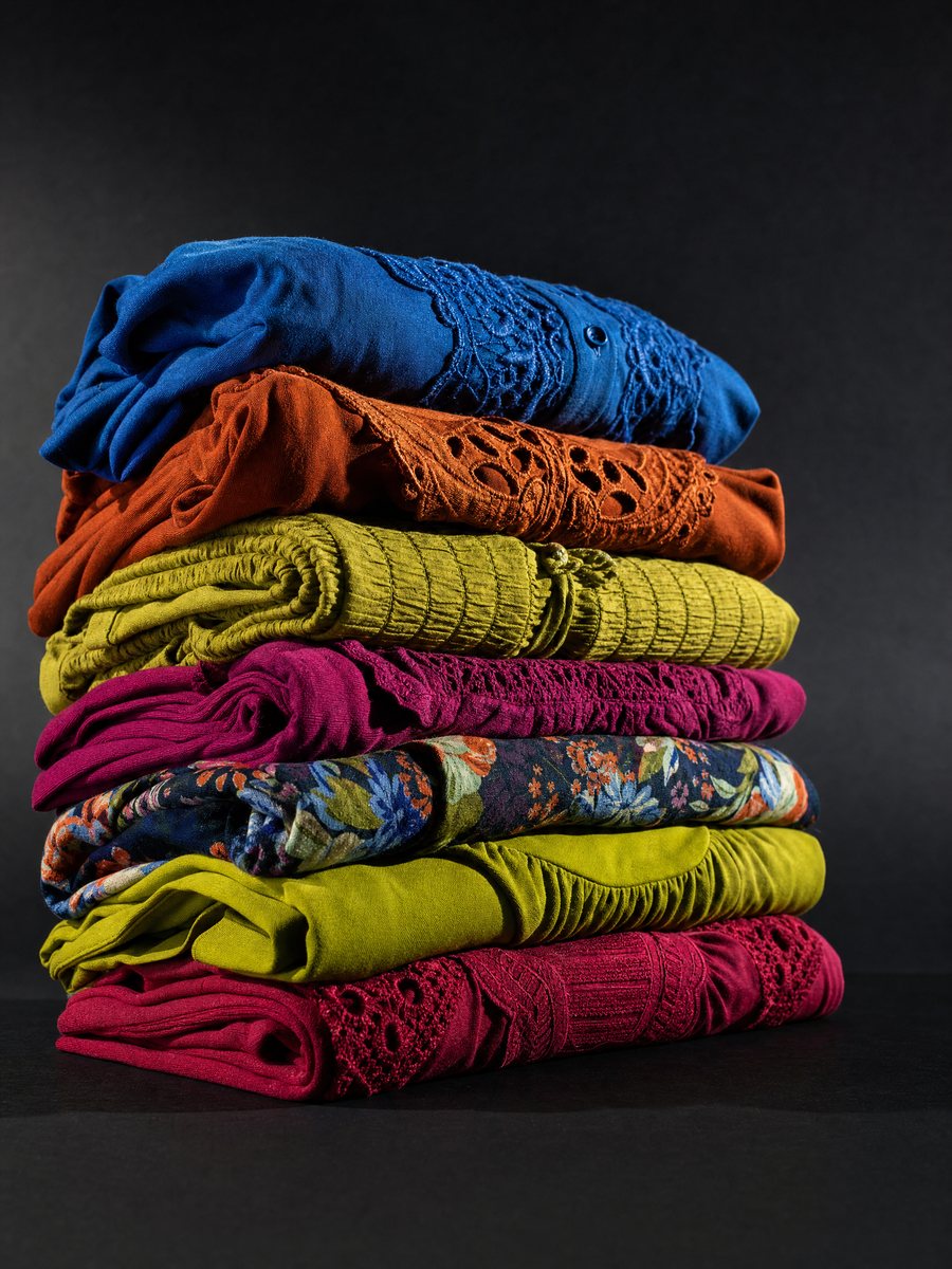 Folded women's blouses and dresses in bold colors